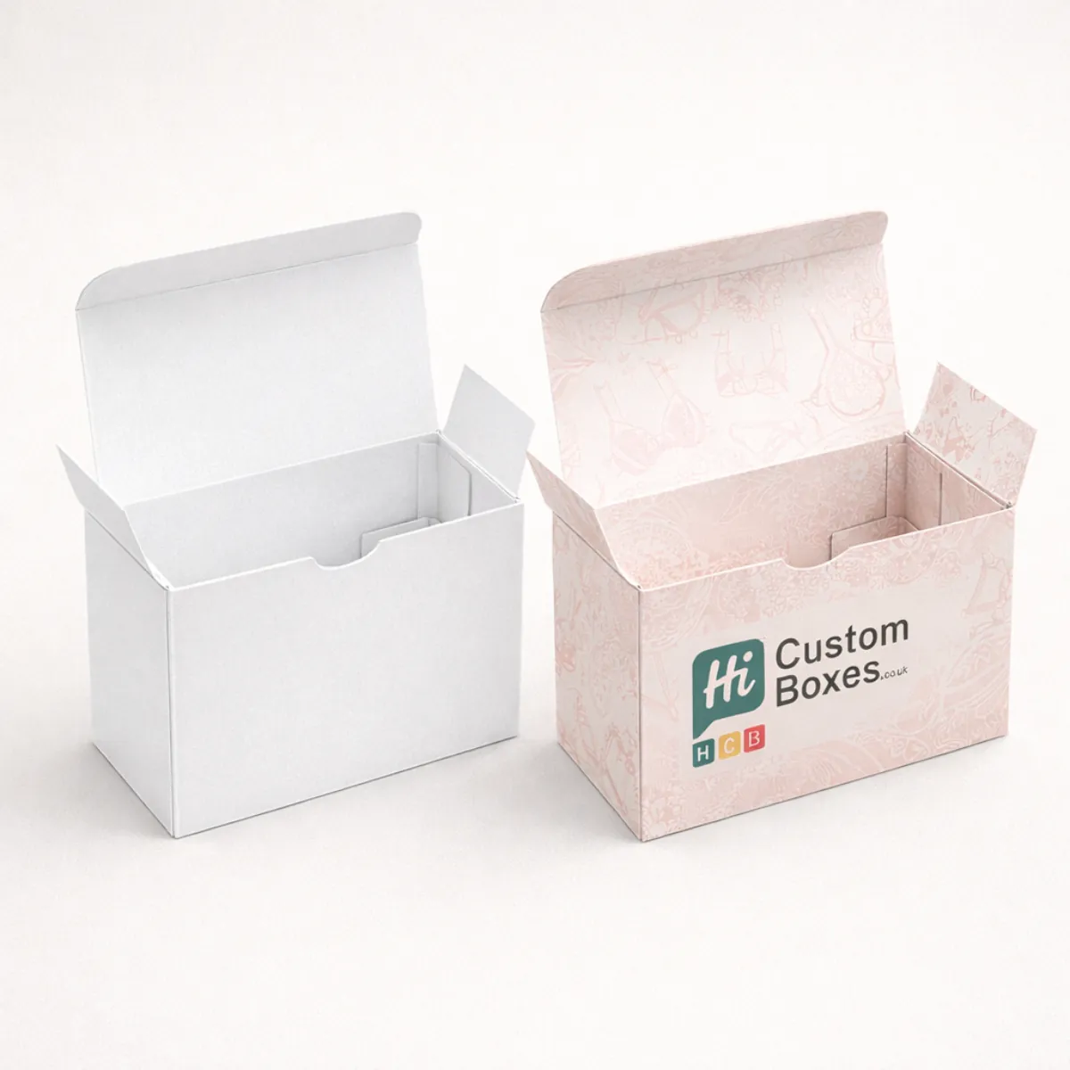 Deep rectangular tuck-top boxes in white and soft pink- displaying internal flaps and printed branding- class=